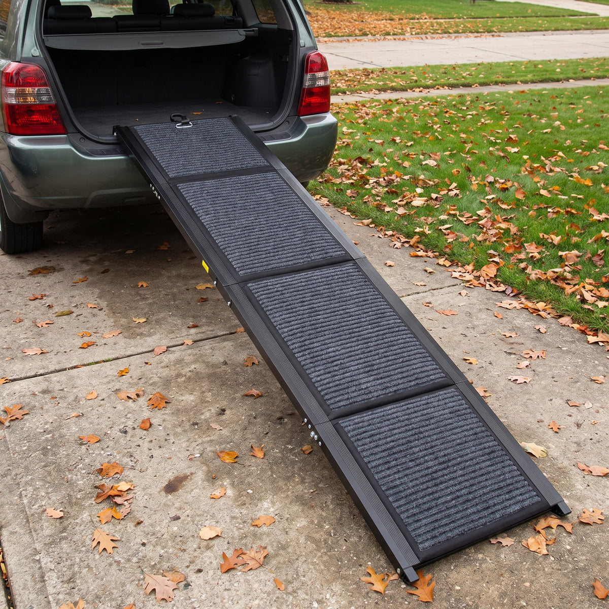 Folding dog car ramp opened from the driveway to the cargo floor of an SUV