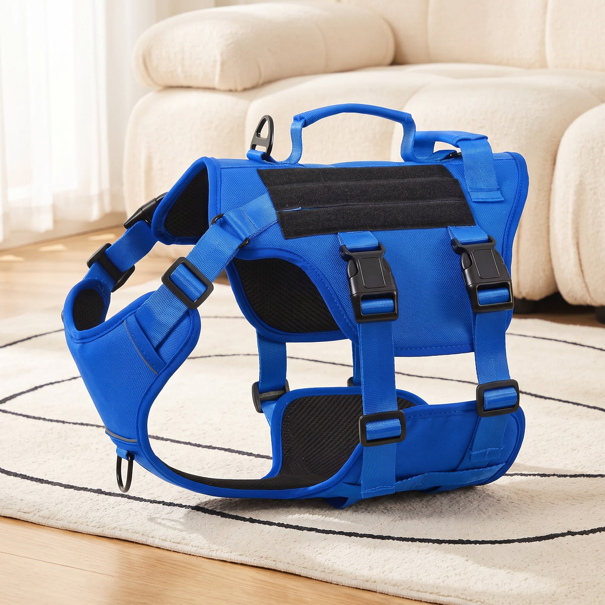 Blue dog harness with two handles on a rug in a living room