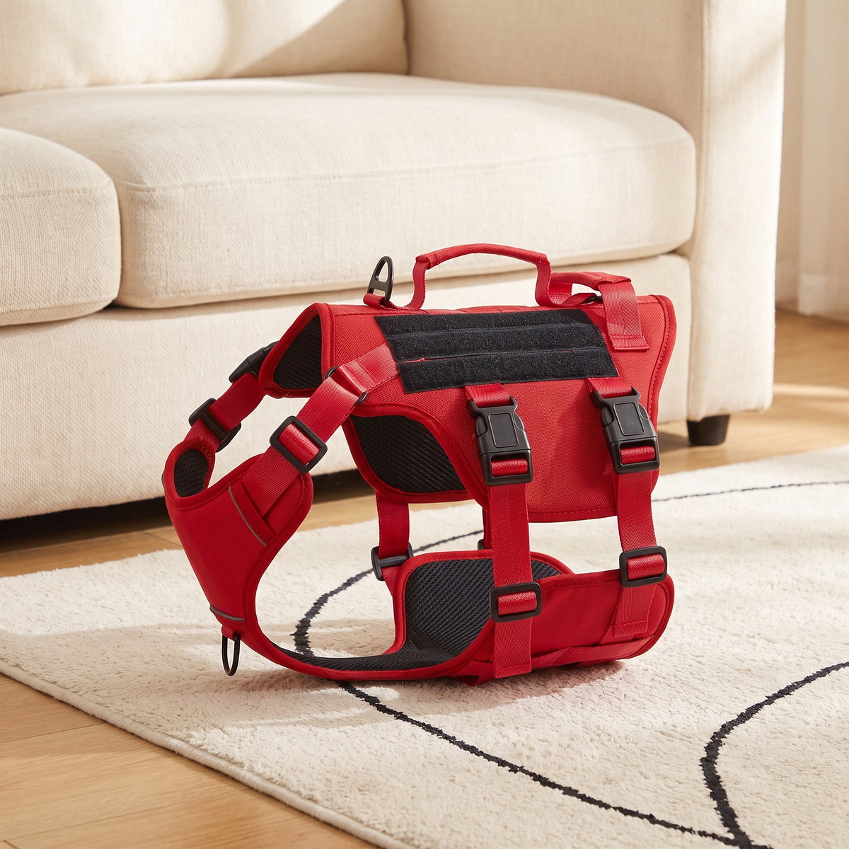 Red dog harness with two handles on a rug in a living room