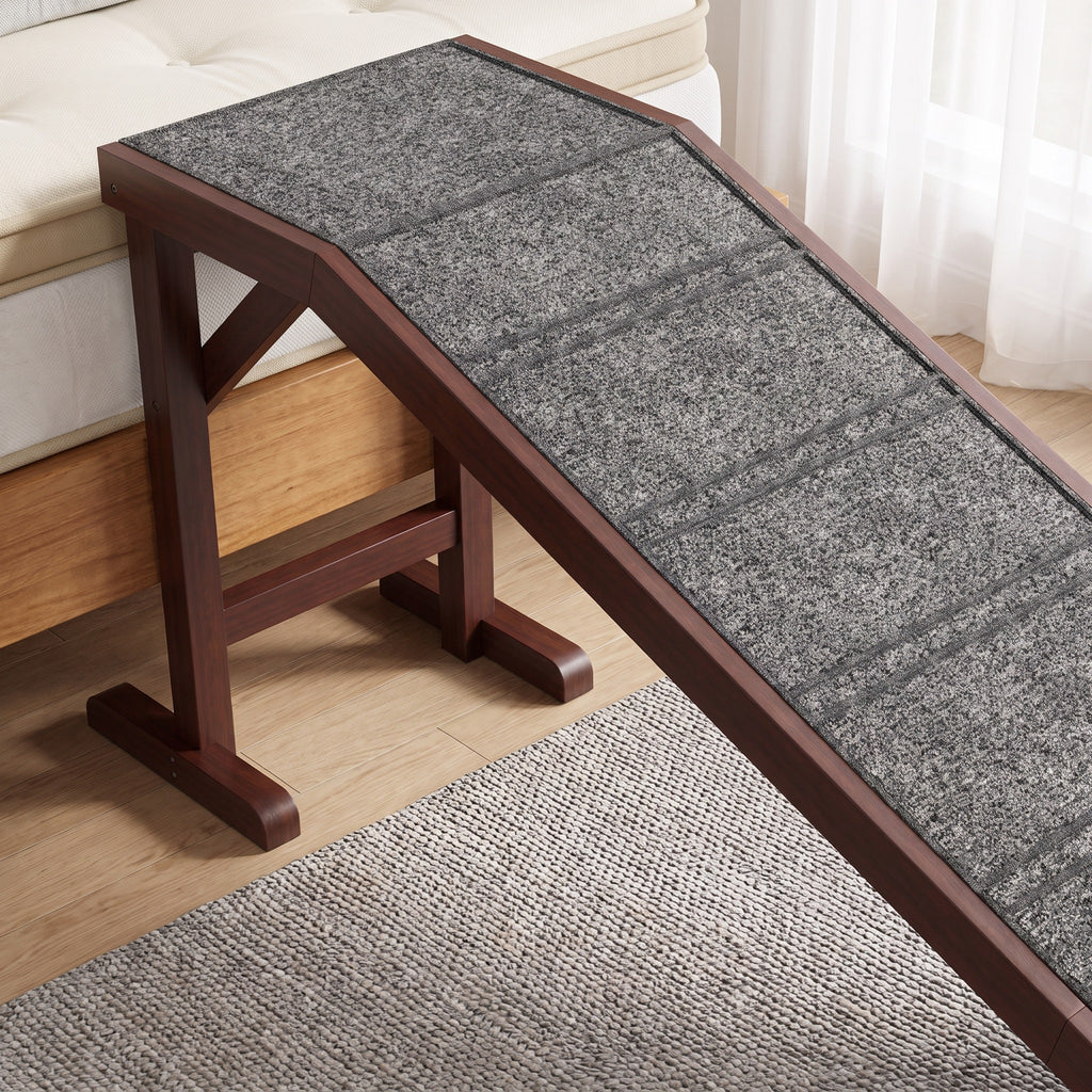The top platform and wooden legs of the dog ramp beside a bed, close up